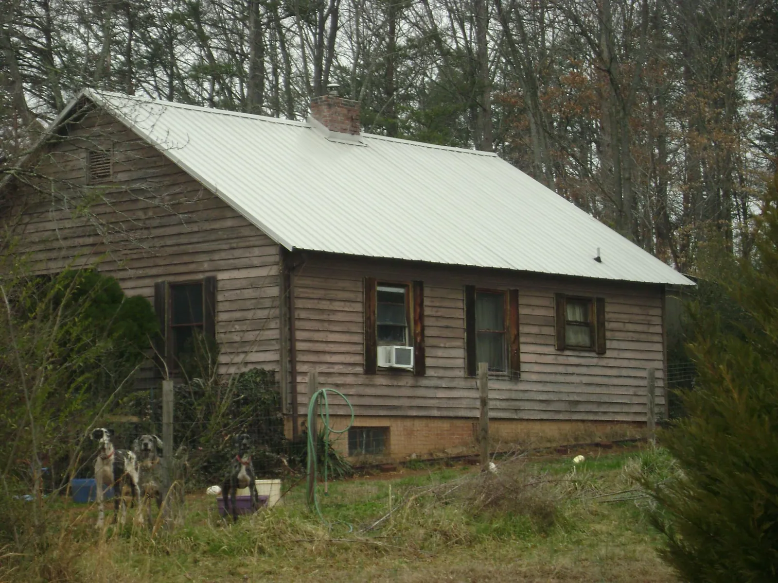 White metal roof on an old wood sided farmhouse, from a Asphalt Shingle Roof Repair job in Terrell